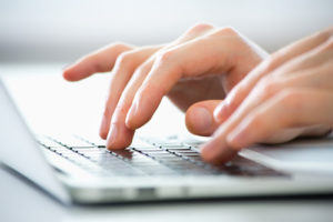 fingers typing on laptop keyboa