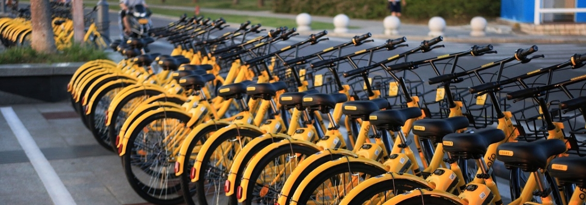 yellow bicycles stacked on a public rack