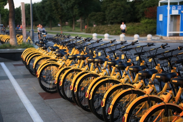 yellow bicycles stacked on a public rack